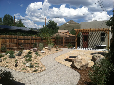 Bermed planting beds, crushed stone walkways, flagstone patio with fire pit.  Pergola built off of existing garage and drip system providing water to all plants and trees.